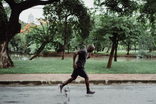 A man jogging on a path in a vibrant green park, showcasing a healthy lifestyle.