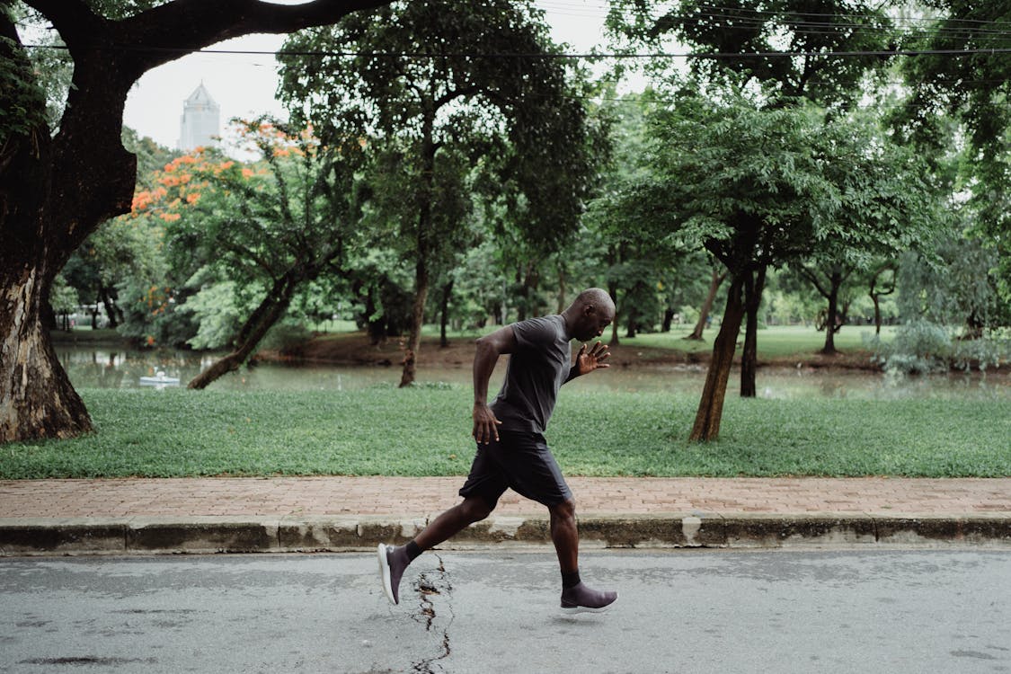 Free Man In Gray T-Shirt And Black Shorts Running Stock Photo