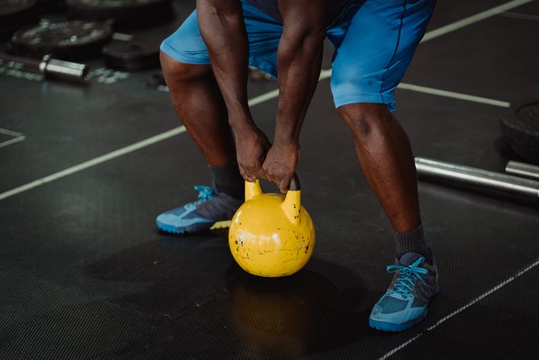 Persona entrenando fuerza funcional con una kettlebell