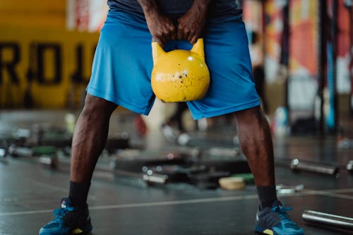 Person Using Yellow Kettlebell