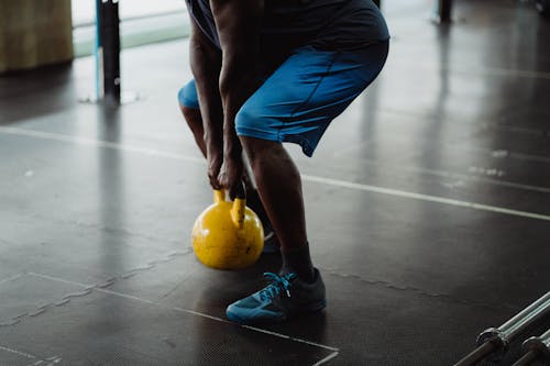 Person Using Yellow Kettlebell