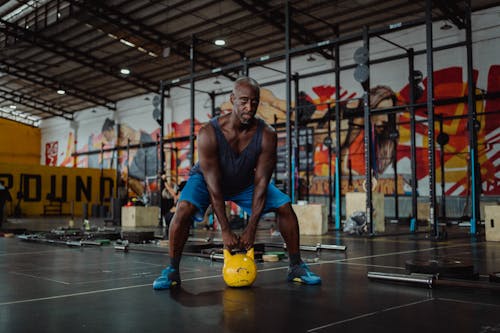 Man Using Yellow Kettlebell