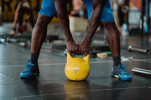 Person Using Yellow Kettlebell