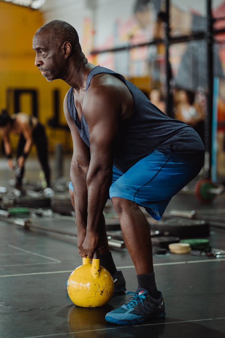 Photo Of Man Using Yellow Kettlebell