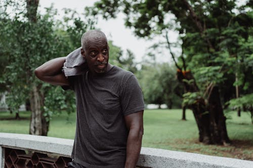 Man in Gray Crew Neck T-shirt Wiping His Sweat With Face Towel