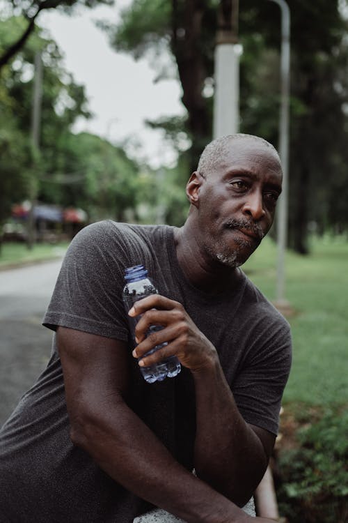 Man in Gray Crew Neck T-shirt Holding Bottled Water