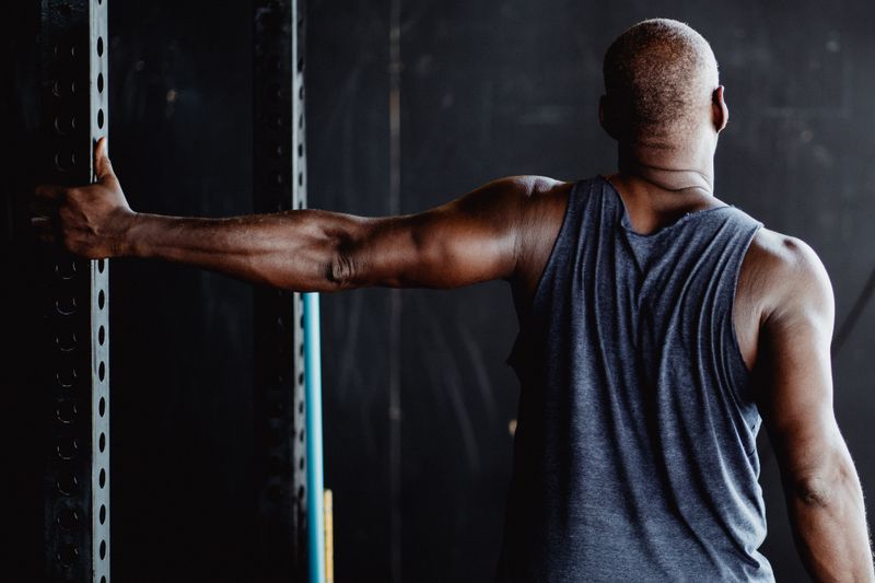 Athlete stretching an arm across the chest — photo by Ketut Subiyanto on Pexels