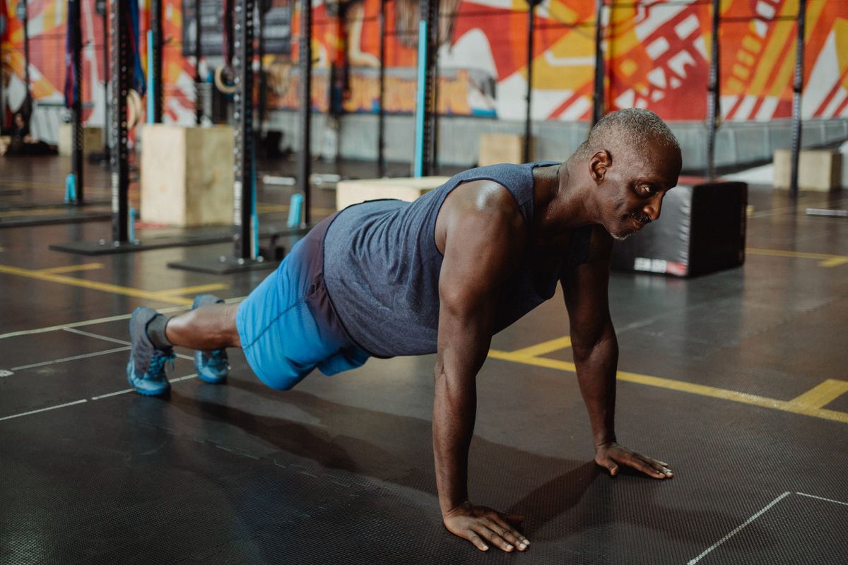 Person performing focused push-ups in a colorful gym setting