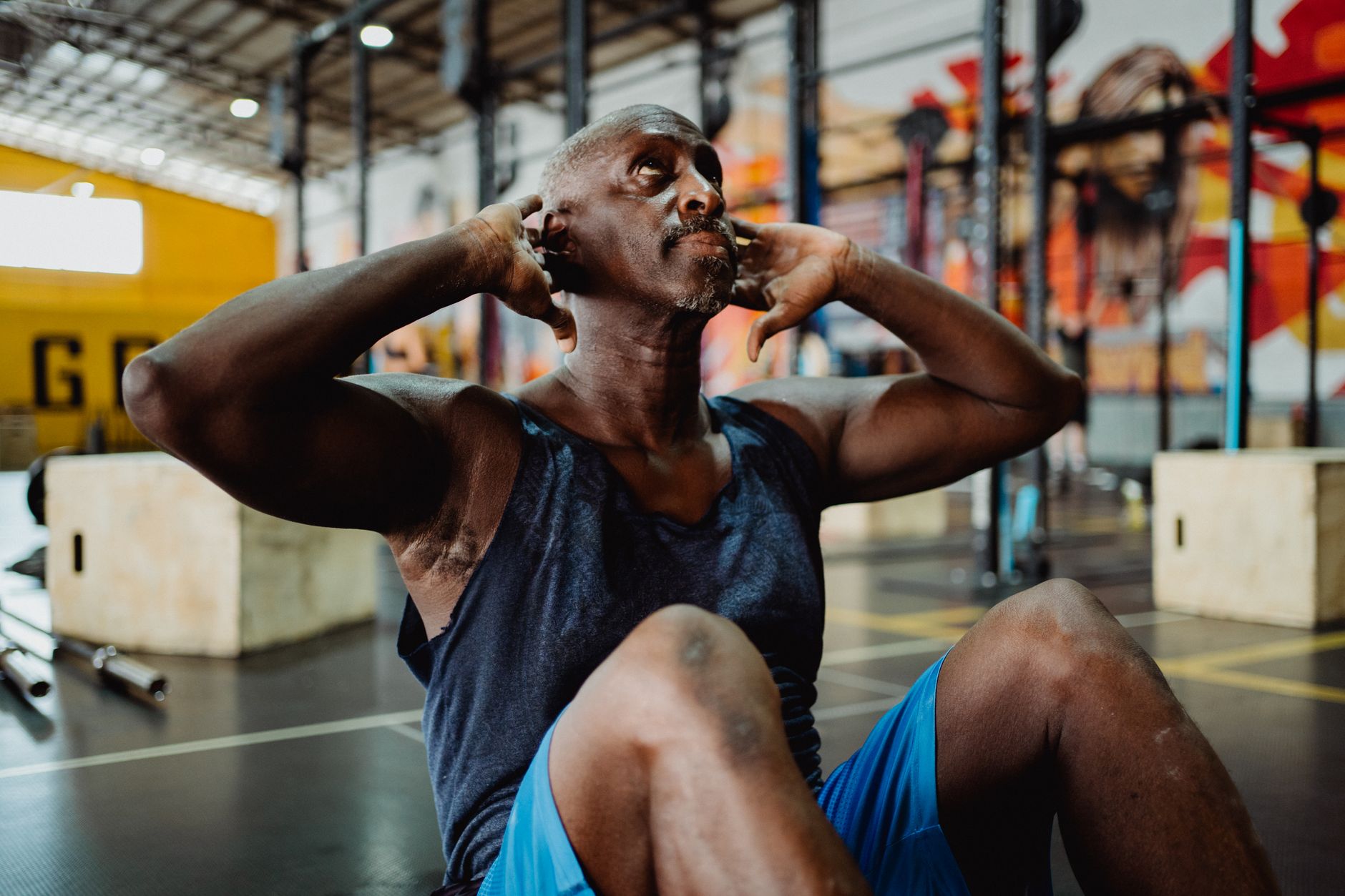 A determined man doing sit-ups in a gym, showcasing strength and focus.