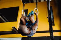 Man Hanging on Hoops Upside Down on a Gym 