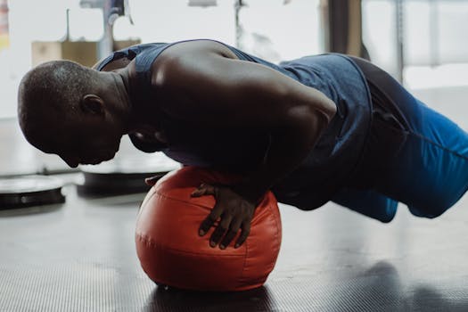 Mature man performing push-up on a red gym ball, focusing on fitness and strength.