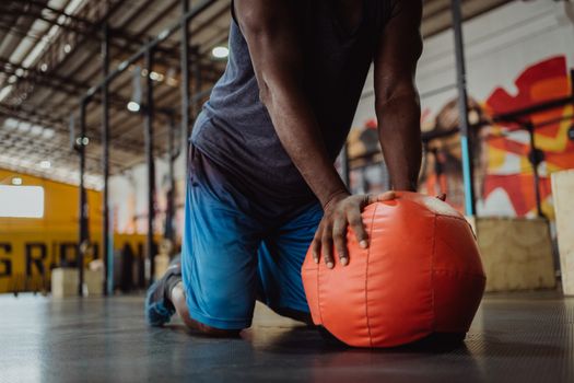 Adult performing exercise on orange gym ball indoors, highlighting strength and fitness.