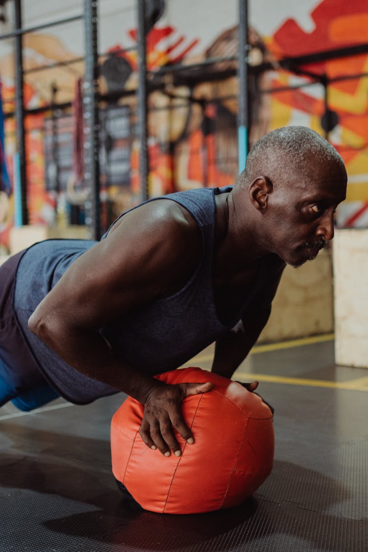 Photo Of A Man Using Orange Gym Ball 