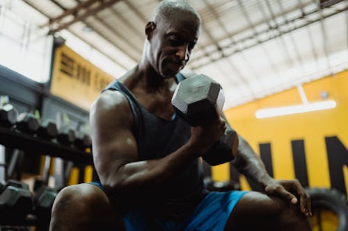 Free Man in Blue Tank Top Holding Black Dumbbell Stock Photo