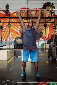 A determined athlete lifts a heavy barbell in a colorful gym, showcasing strength and fitness.