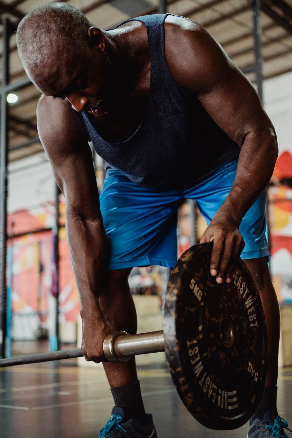 Member loading a plate between HIIT rounds