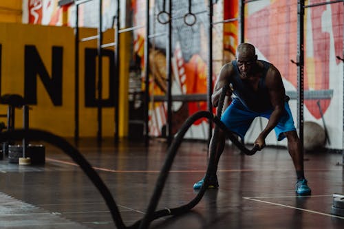 Free Man in Blue Shorts Doing Exercise with Battle Ropes Stock Photo