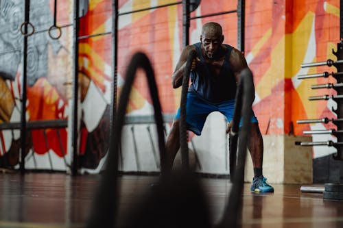 Free Man in Blue Shorts Exercising with Battle Ropes Stock Photo