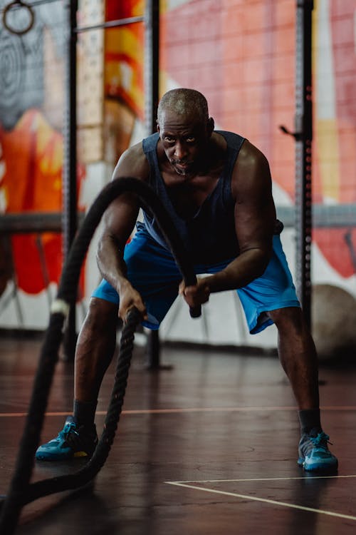 Free Man in Black Top and Blue Shorts Doing Exercise with Battle Ropes Stock Photo