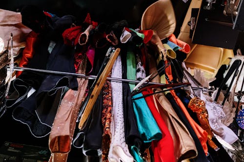 Assorted Clothes Hanged on Brown Wooden Rack