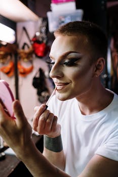 A drag queen skillfully applying makeup in a vibrant dressing room, showcasing transformation.