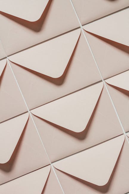 Top view of rows of simple light beige unsealed envelopes in light of lamps