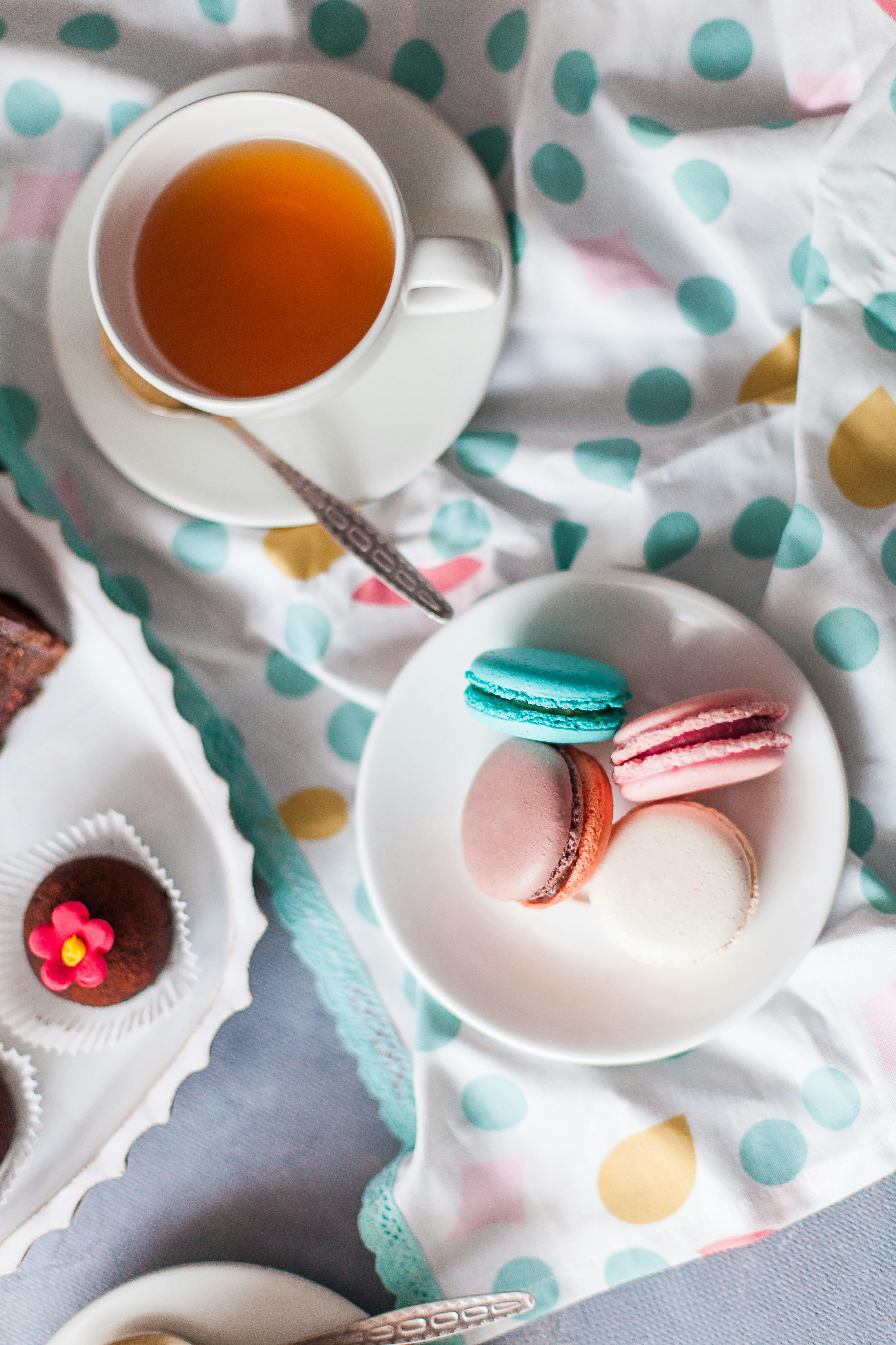 cup of tea and desserts on table in bright room