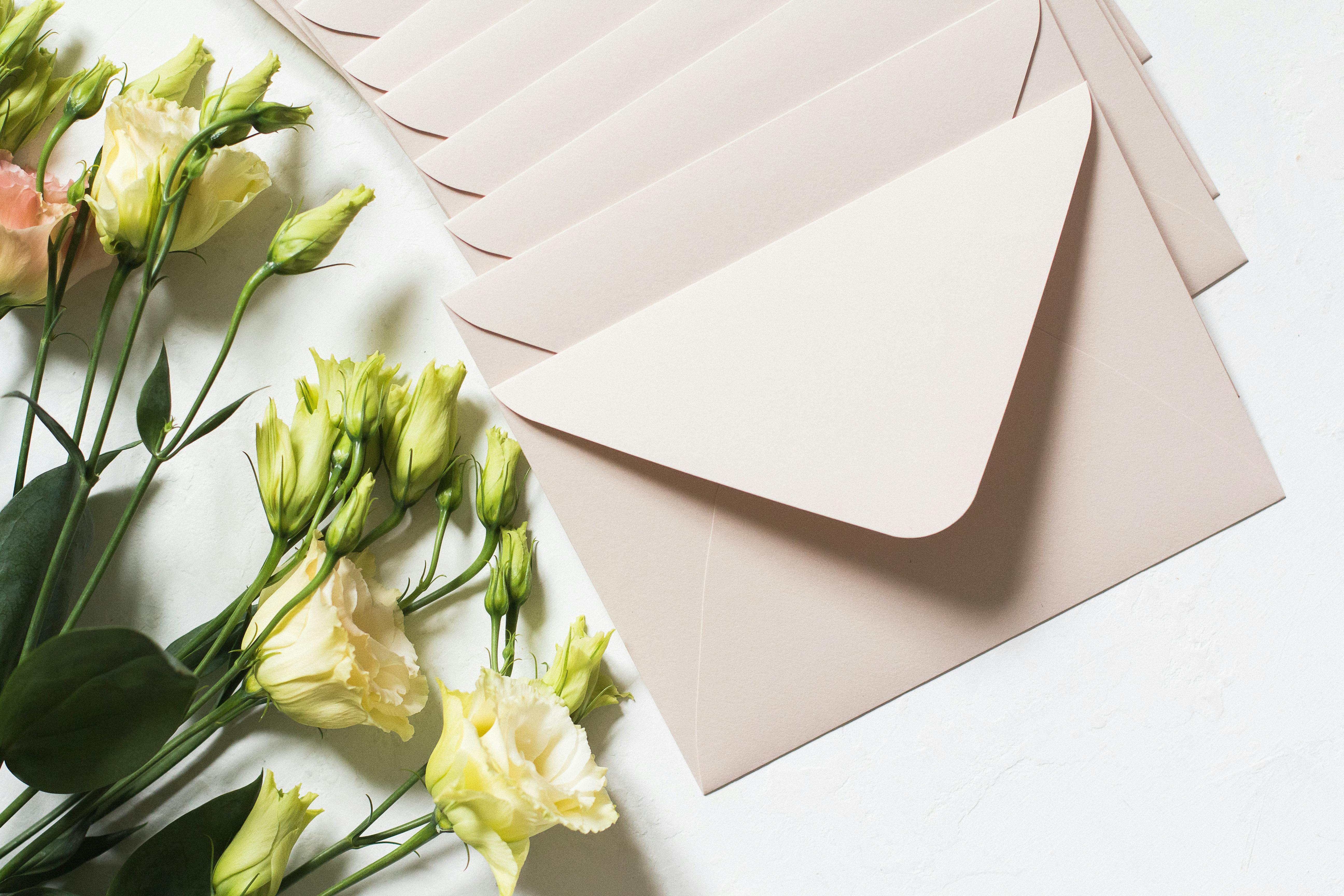 bunch of envelopes near bouquet of flowers