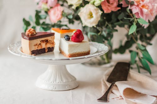 Pieces of cake on plate in room decorated with bouquet of flowers