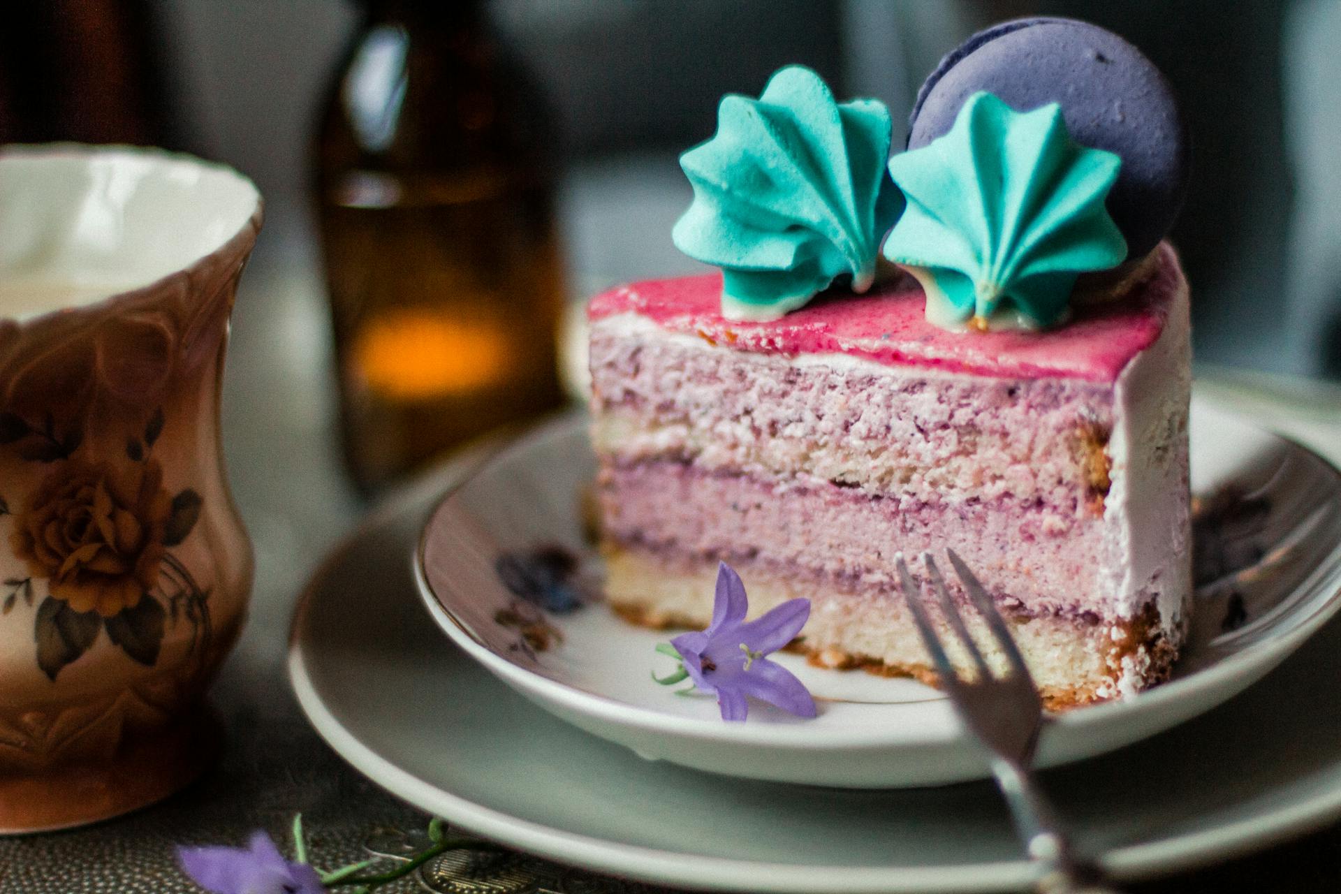 Piece of pink cake with meringues and macaron