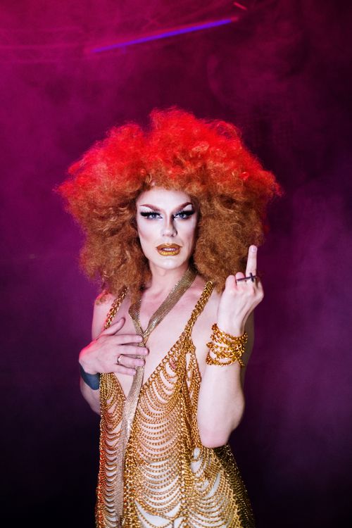 Free A glamorous drag queen with fiery hair and bold makeup expresses individuality and pride. Stock Photo