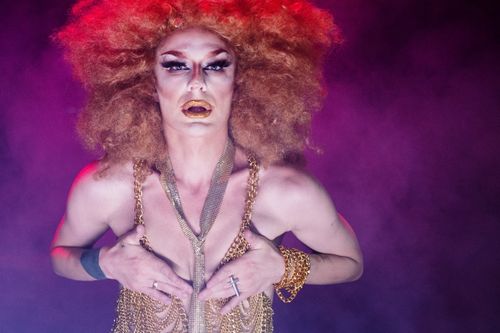 Free Vibrant and colorful drag queen striking a dynamic pose in ornate costume with bold makeup. Stock Photo