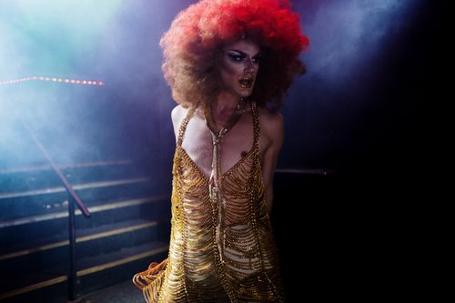 Free A stunning drag queen with vibrant makeup and attire performing on stage under colorful lights. Stock Photo