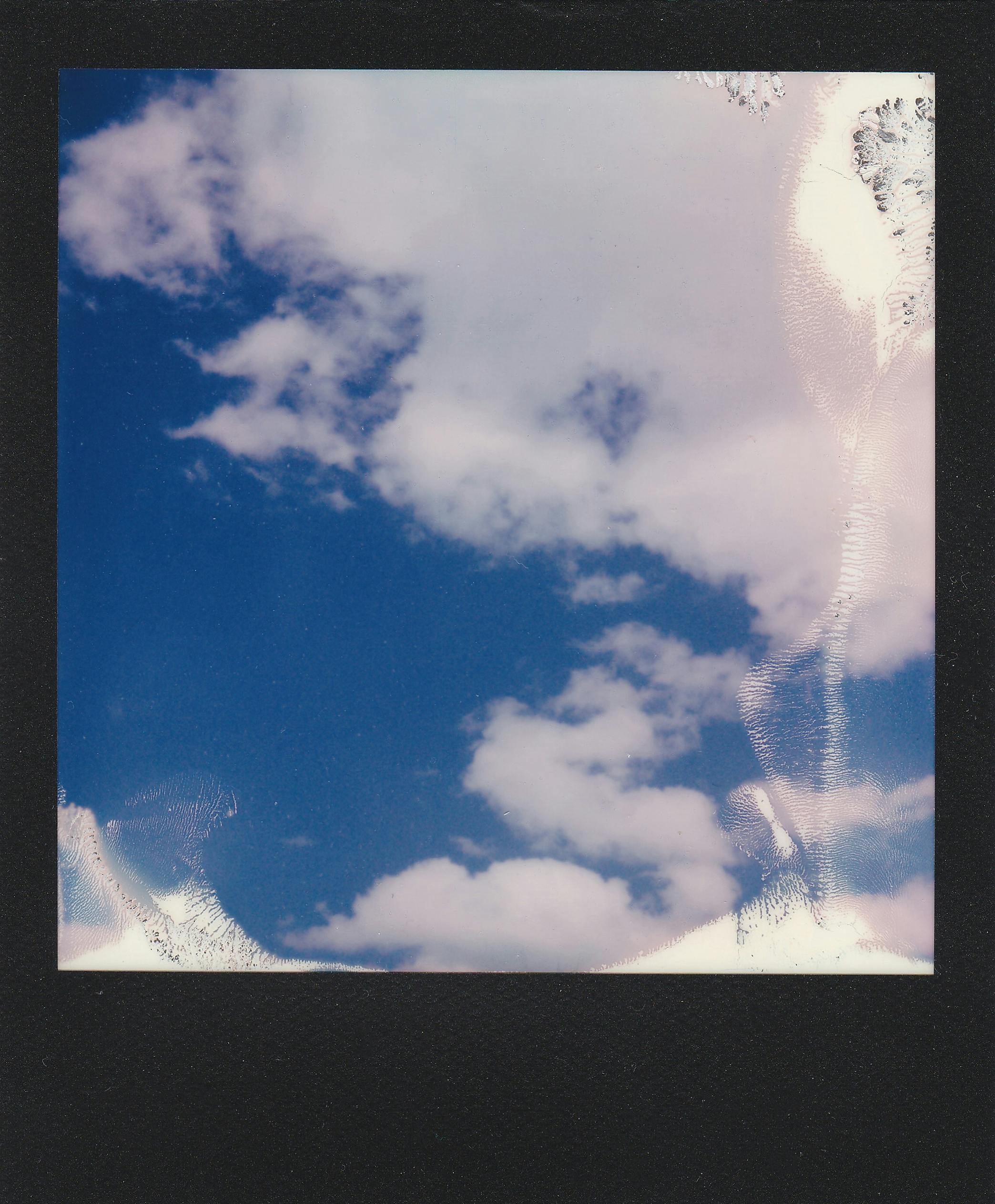 A peaceful image of a bright blue sky filled with fluffy white clouds.