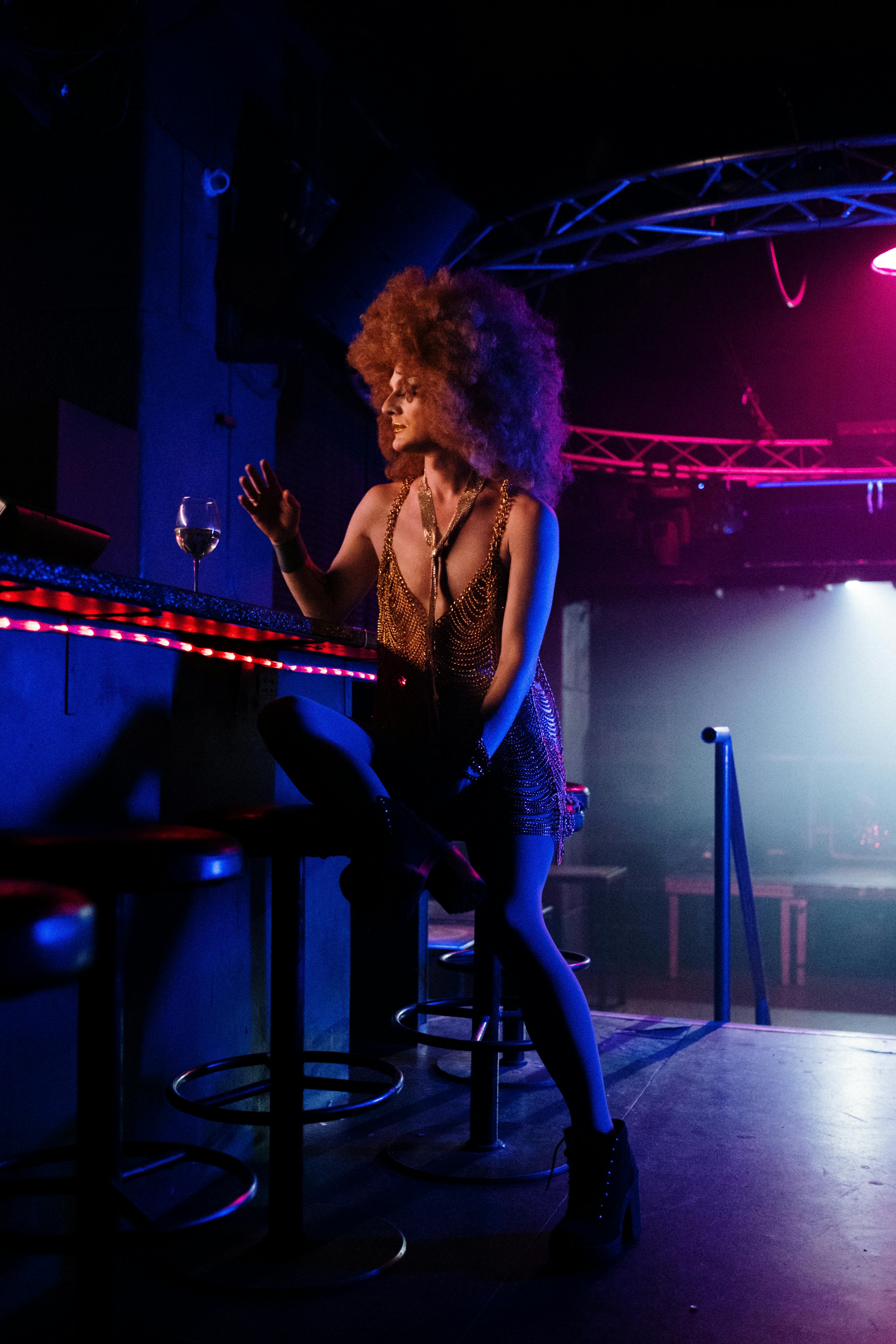 drag queen sitting at a bar