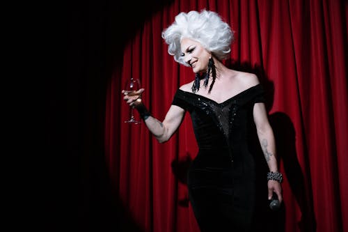 Drag Queen on Stage Holding a Wine Glass