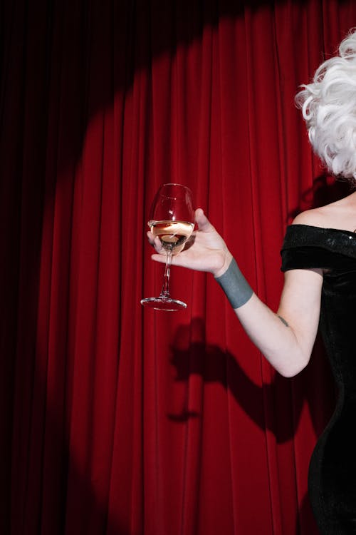Free Person on Stage Holding a Glass of Wine Stock Photo