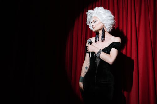 Drag Queen Holding a Microphone on Stage