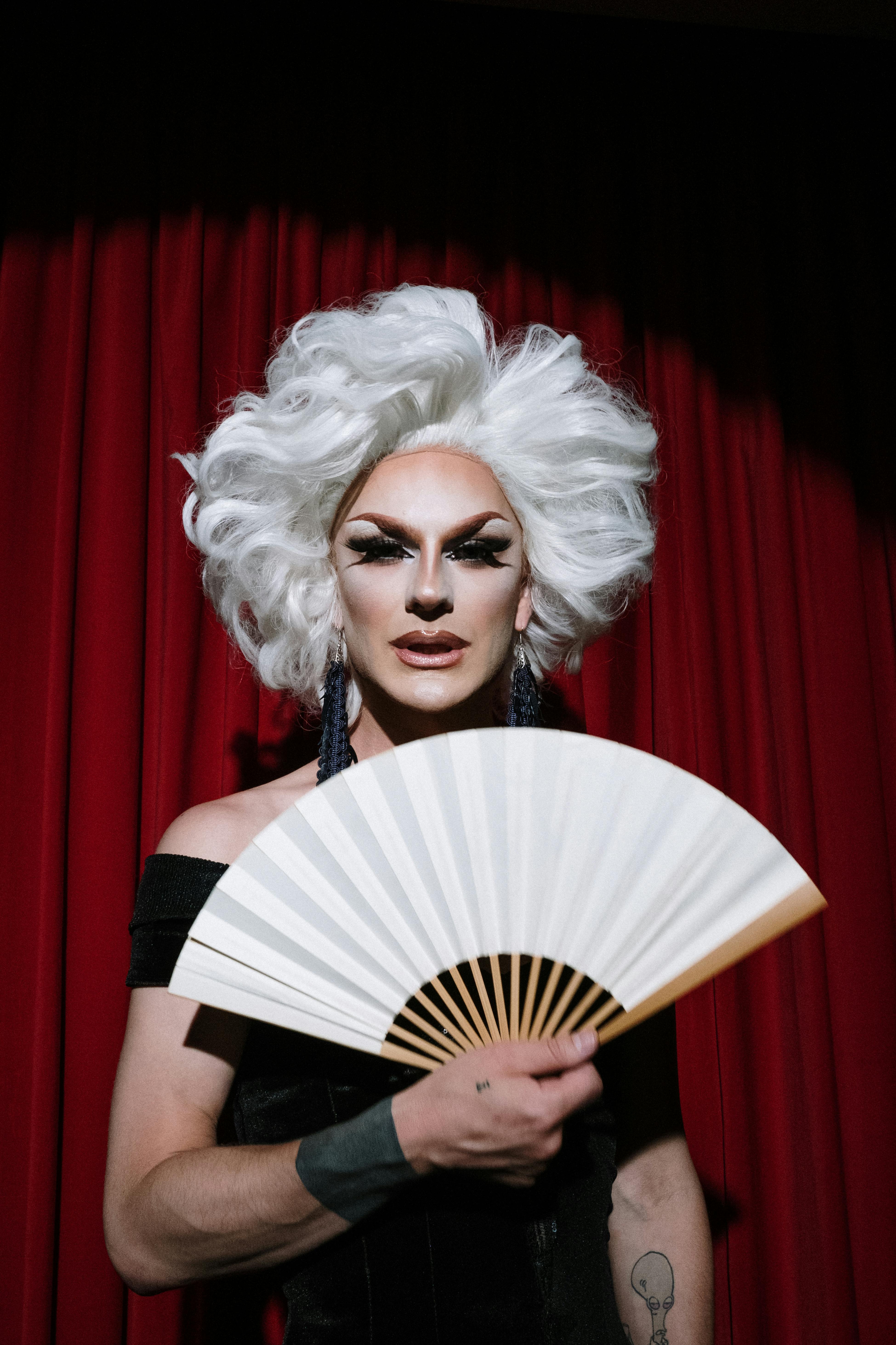 Drag Queen Holding A White Hand Fan Free Stock Photo