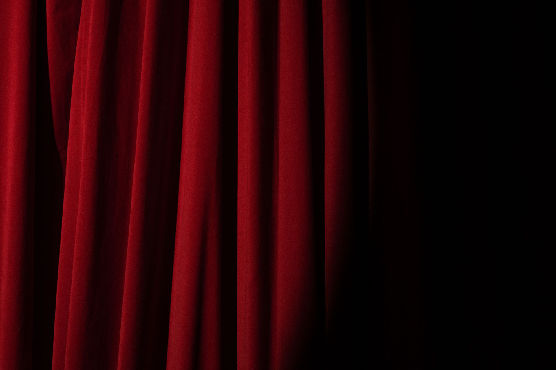 A heavy red velvet curtain on a vintage theatre stage