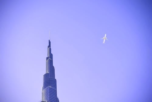 免费 白色飞机飞越大厦 素材图片