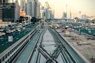 迪拜的城市景观充满动感，前景中可见繁忙的交通和铁路轨道