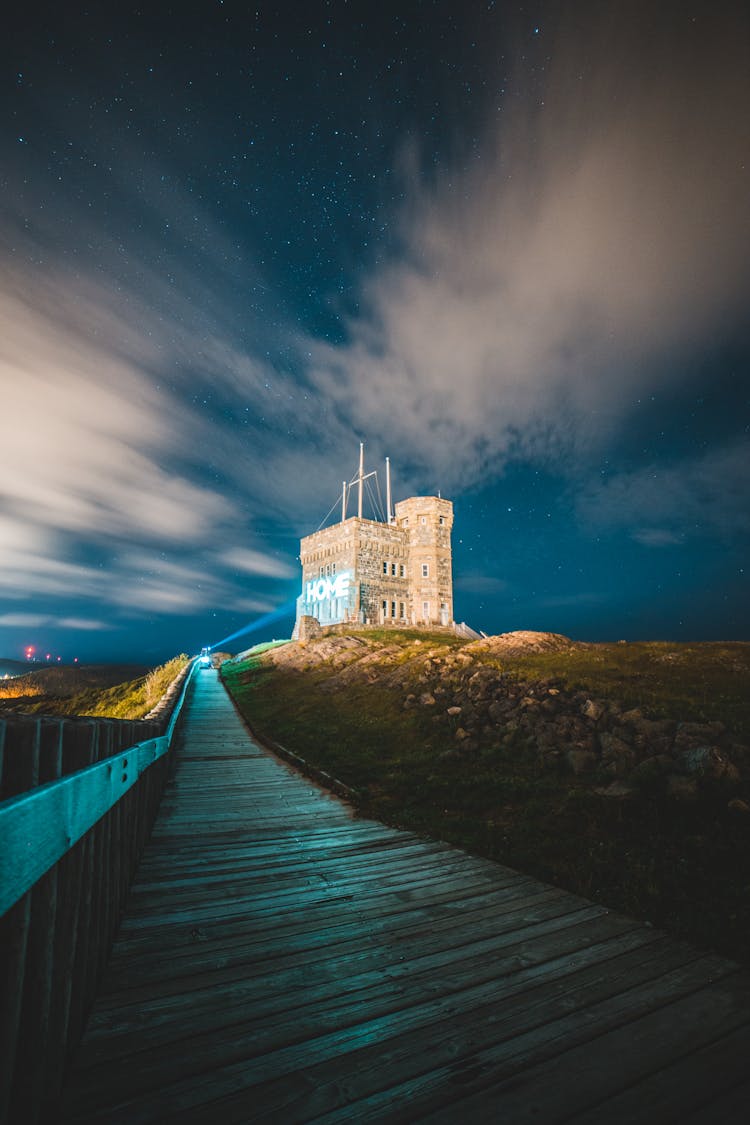 Narrow Boardwalk And Old Stone House Under Night Sky