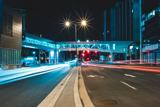 Asphalt road going through illuminated buildings located on city street at night time