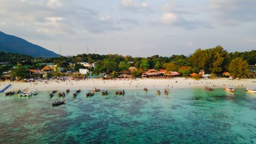 Free A beautiful aerial view of a tropical beach with boats and lush greenery, ideal for vacation. Stock Photo