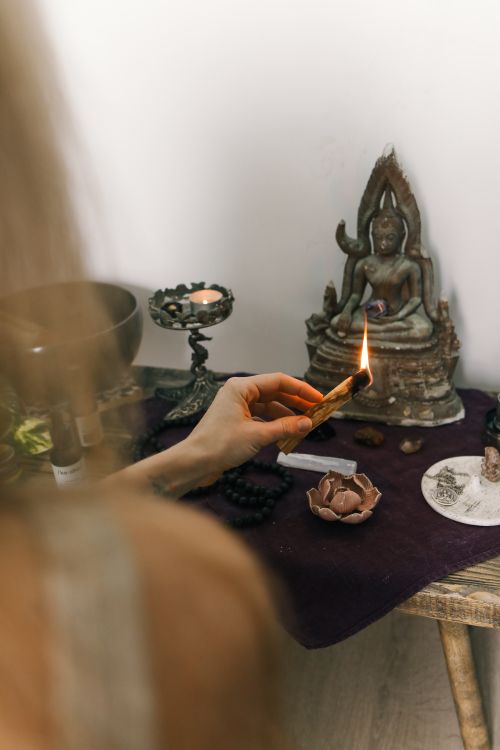 Free A serene spiritual setup with sage burning beside a Buddha statue, promoting calm and meditation. Stock Photo