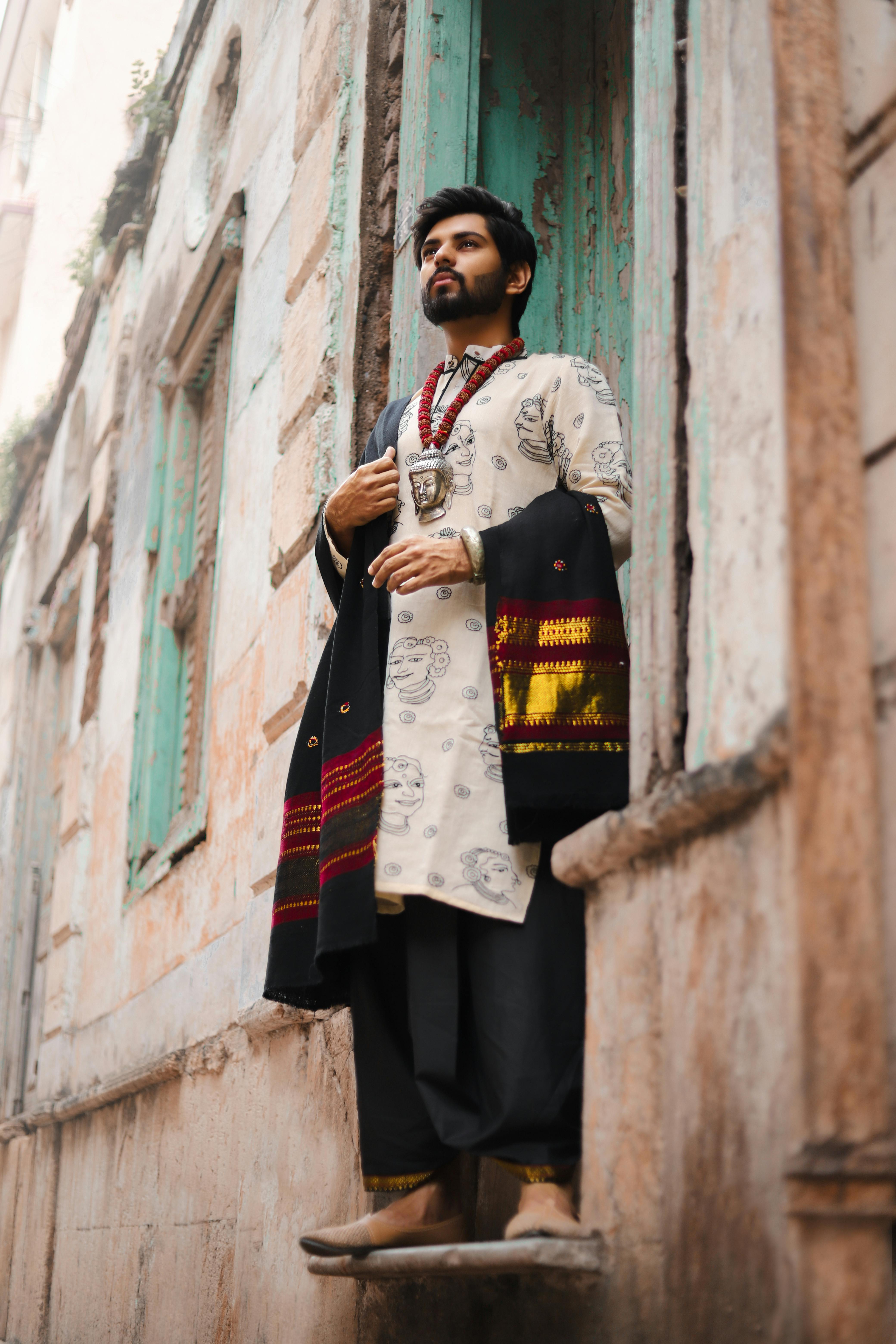 Man in traditional Indian wear posing in Surat’s historic streets.