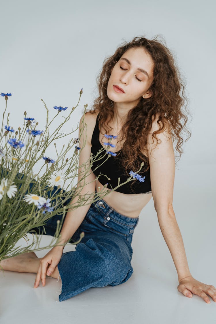 Woman Sitting On The Floor Near A Plant