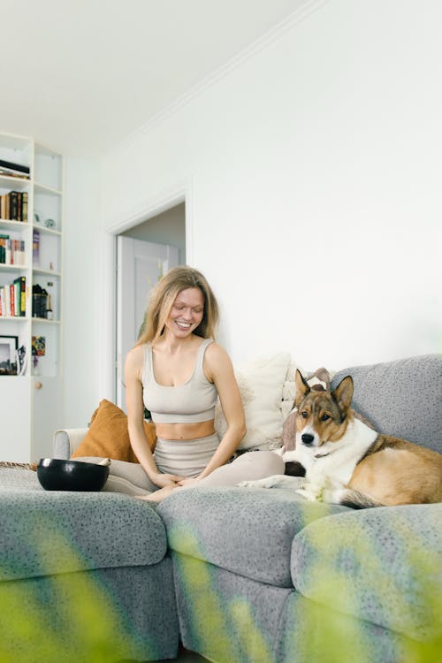 Free Woman Sitting on the Sofa with her Dog Stock Photo