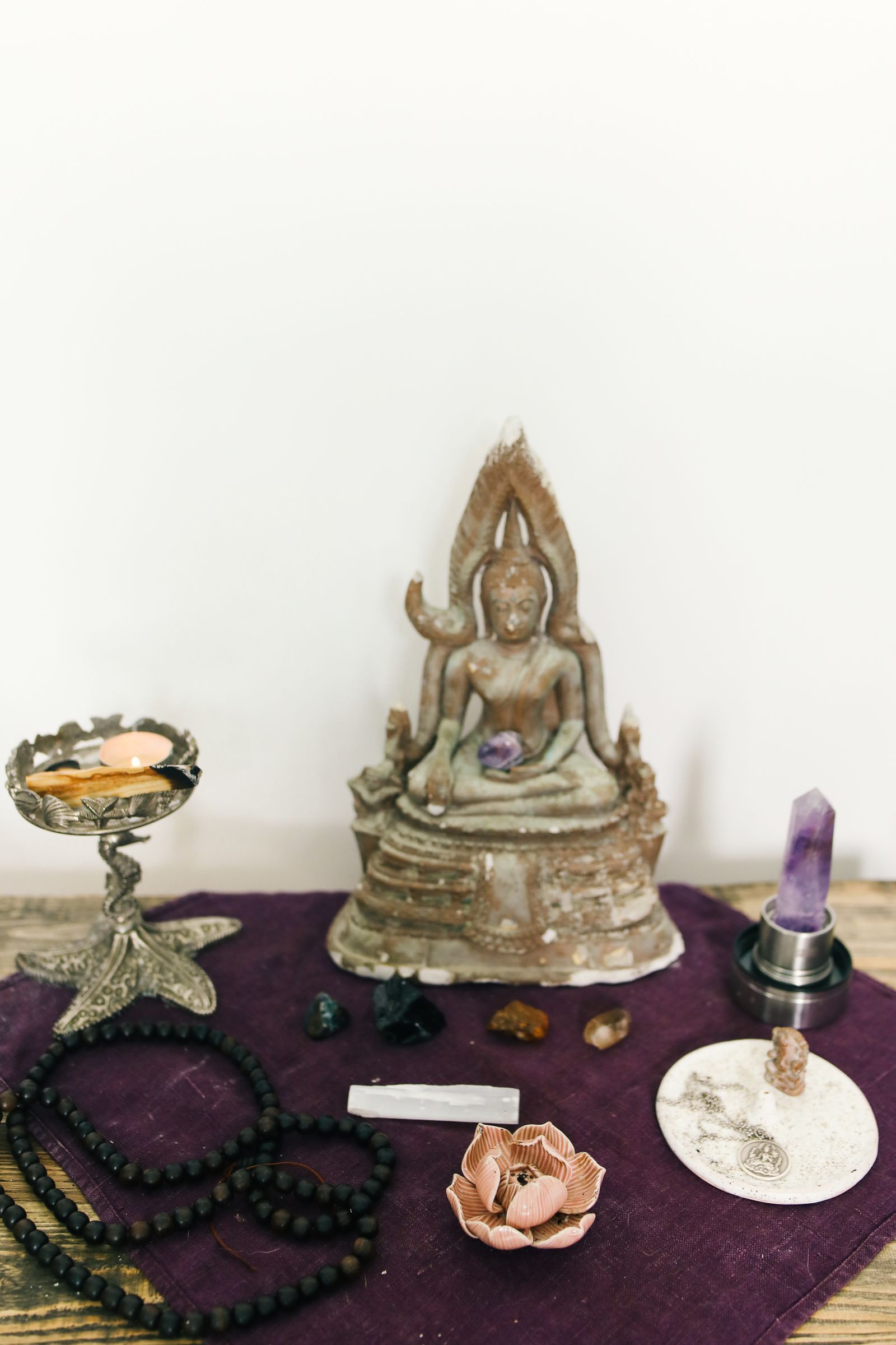 Peaceful meditation altar setup with crystals, candles, and a Buddha figurine